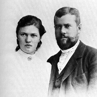 A grayscale photograph of Max Weber and Marianne Weber standing next to one another. They are both facing toward the right with intense facial expressions. Marianne is wearing a frilly high-neck blouse and Max is wearing a simple suit. Photo Credit: Unknown, 1893 . Source: commons.wikimedia.org