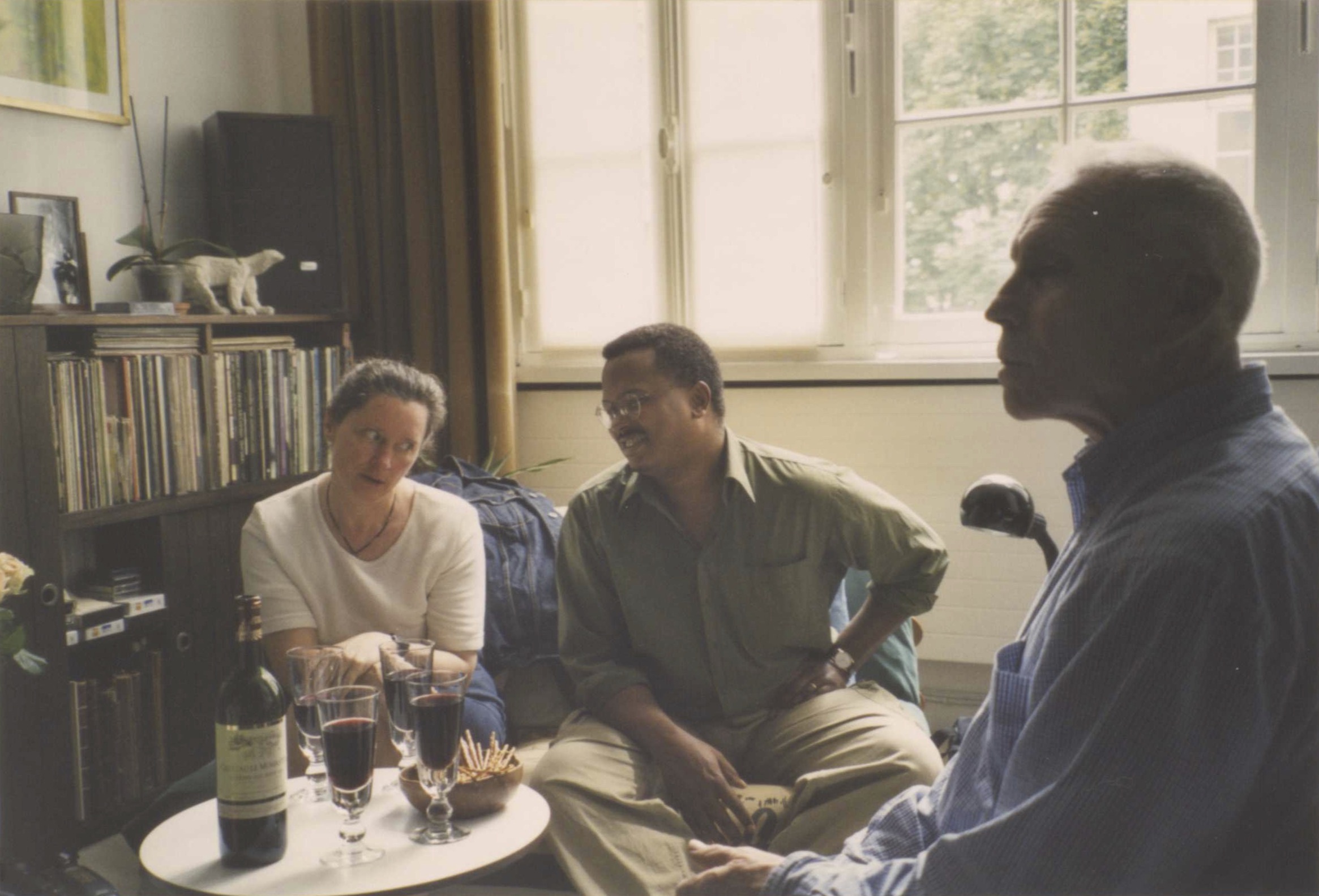 Photo of Godelieve Simons on the left side of the screen. Jake Lamar in the center sitting next to Godelieve Simons. Lamar and Simons are looking at each other but not directly. Robert Trecoine is seated perpendicular to Jake Lamar.