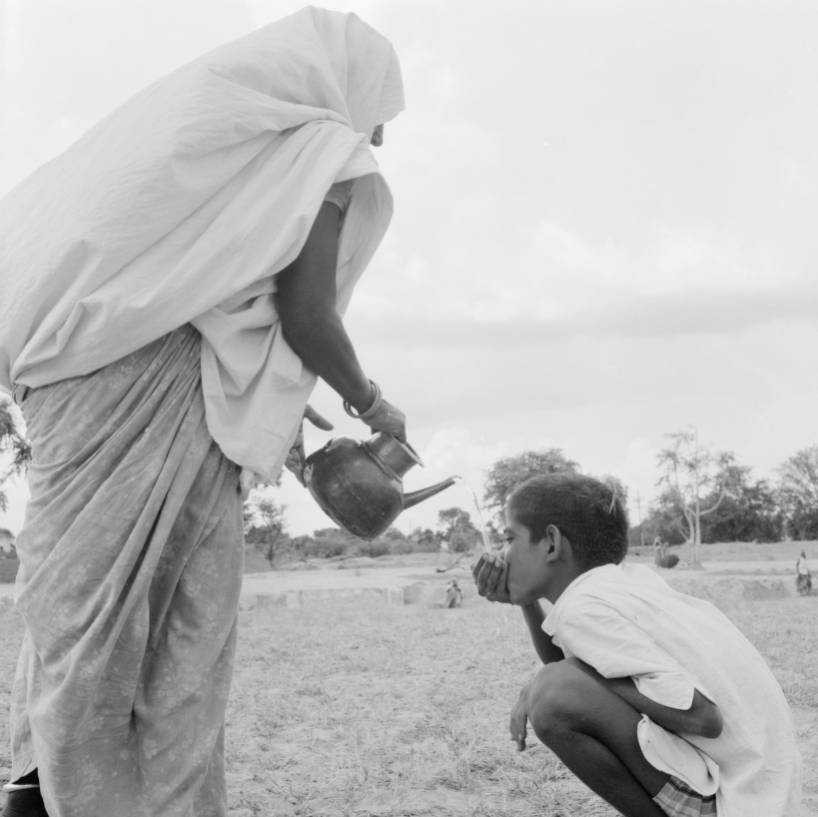 Woman pouring child shepherd some tea.