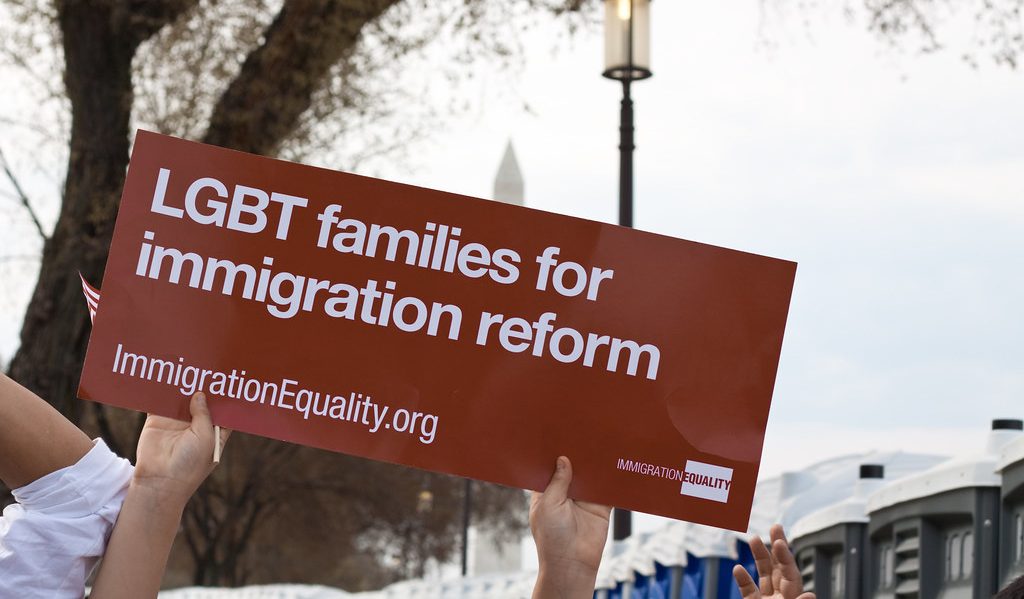 An activist holds a sign that reads “LGBT Families for Immigration Reform”