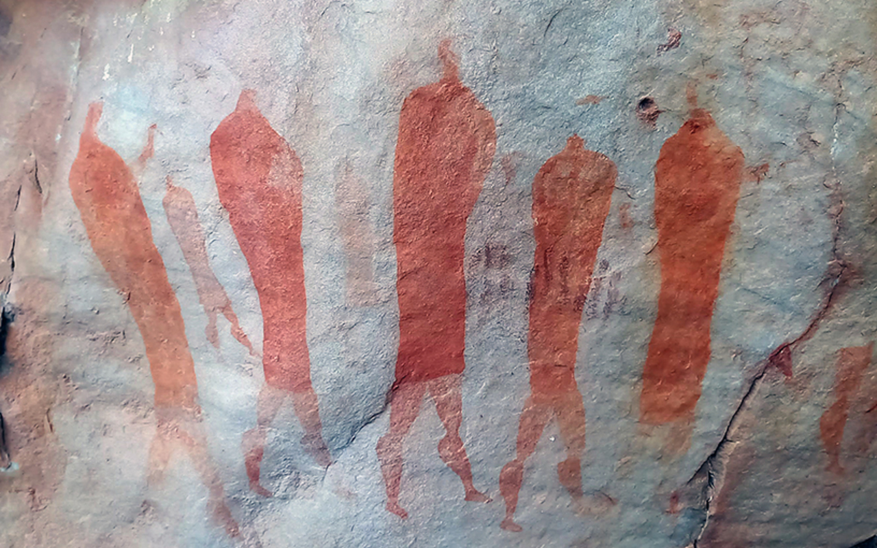 San art of 5 main figures wearing karosses. Located in a sandstone rock shelter near the Stadsaal Caves, Cederberg, South Africa