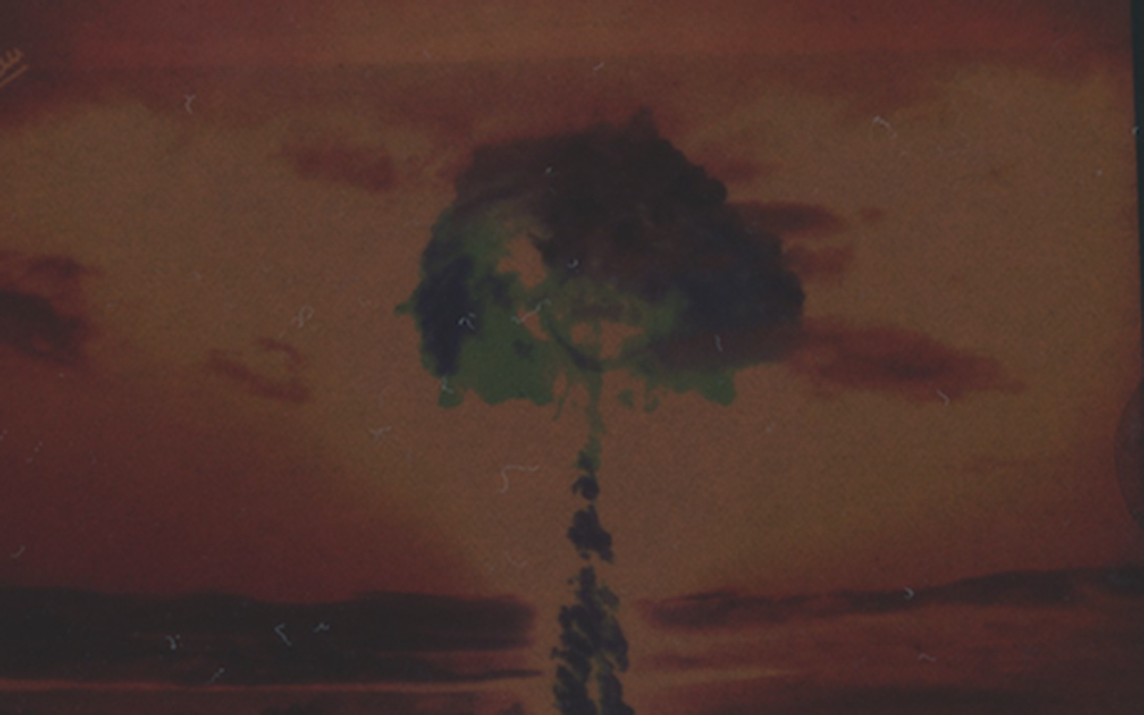 Mural of faces on concrete wall topped with barbed wire.