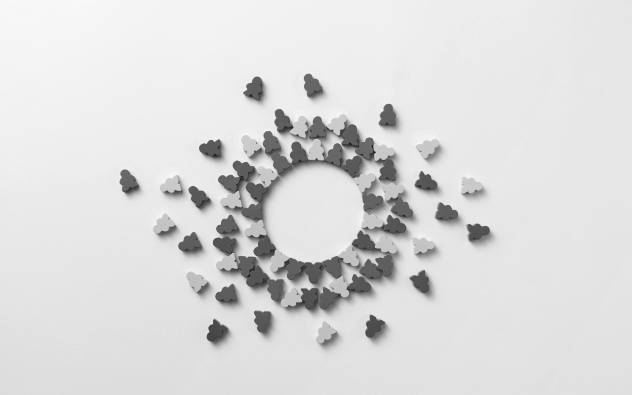 A circular array of human-shaped wooden figures, tightly packed at center and dispersing further outward.