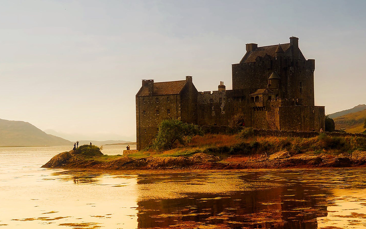 Stone bridge and building next to a body of water