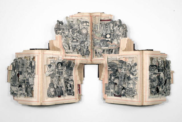 Photograph of a set of books that have been cut by an artist to reveal patterns and images inside.
