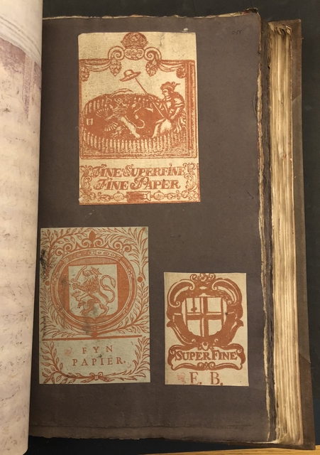 Photograph of a ream wrappers pasted into a large volume of paper specimens