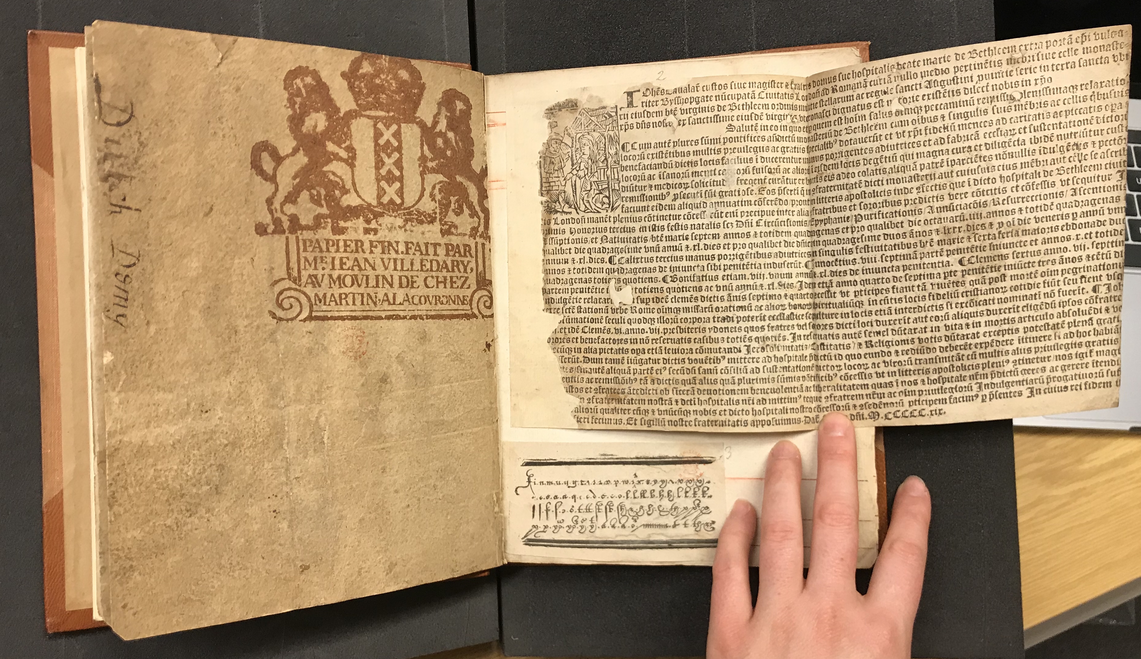 Photograph of a ream wrapper and fragments of early printing pasted into a large volume of specimens