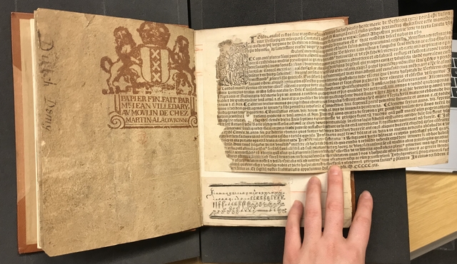 Photograph of a ream wrapper and fragments of early printing pasted into a large volume of specimens