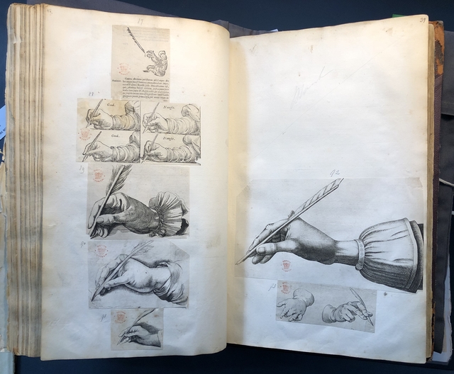 Photograph of images of hands holding quill pens pasted into an album assembled by John Bagford