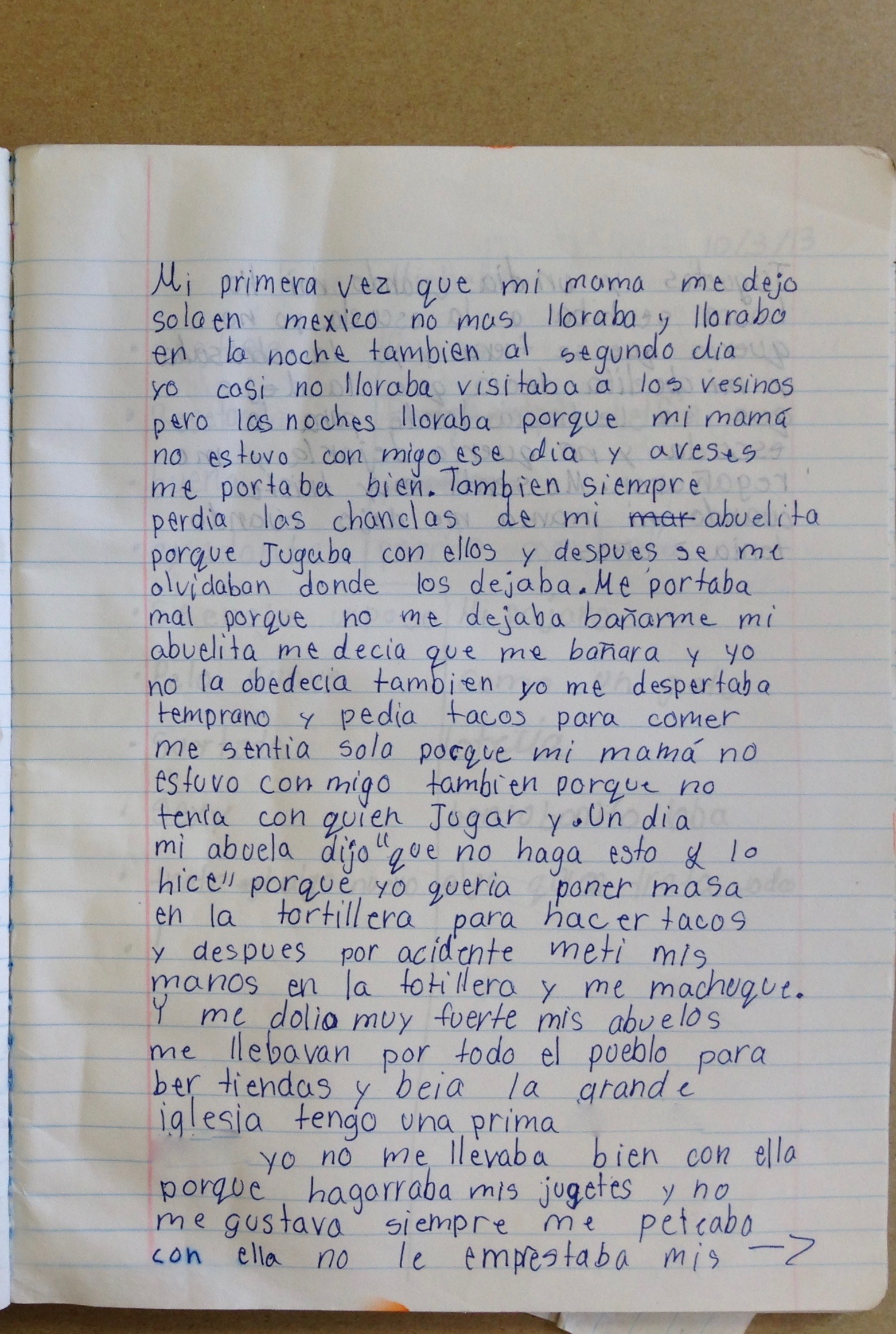 Catalina’s memoir is written by hand in blue ink on lined paper in her writing notebook. An arrow indicates that the story continues on the next page.