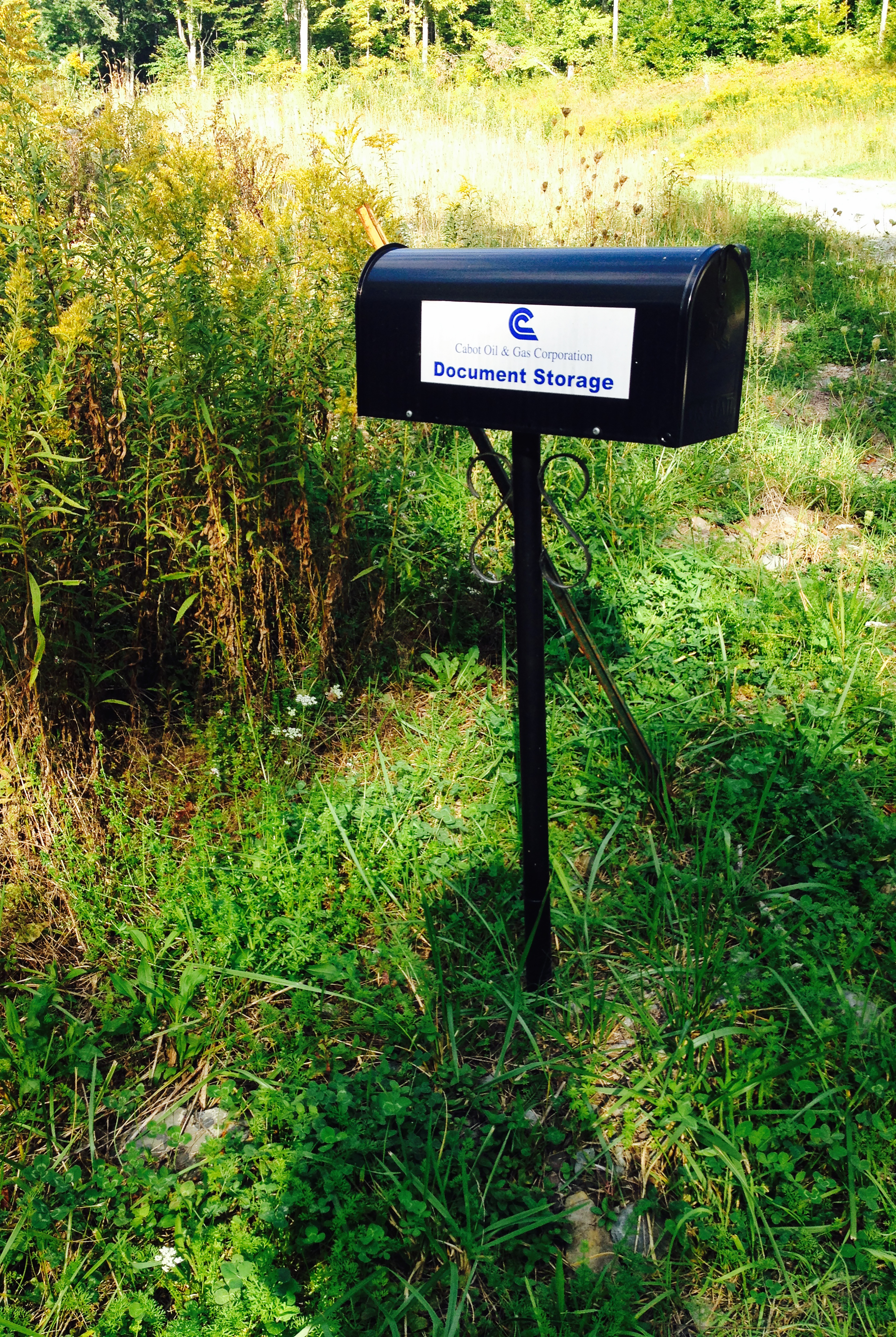 A solitary metal mailbox in a field labeled “Cabot Oil and Gas Corporation Document Storage.”