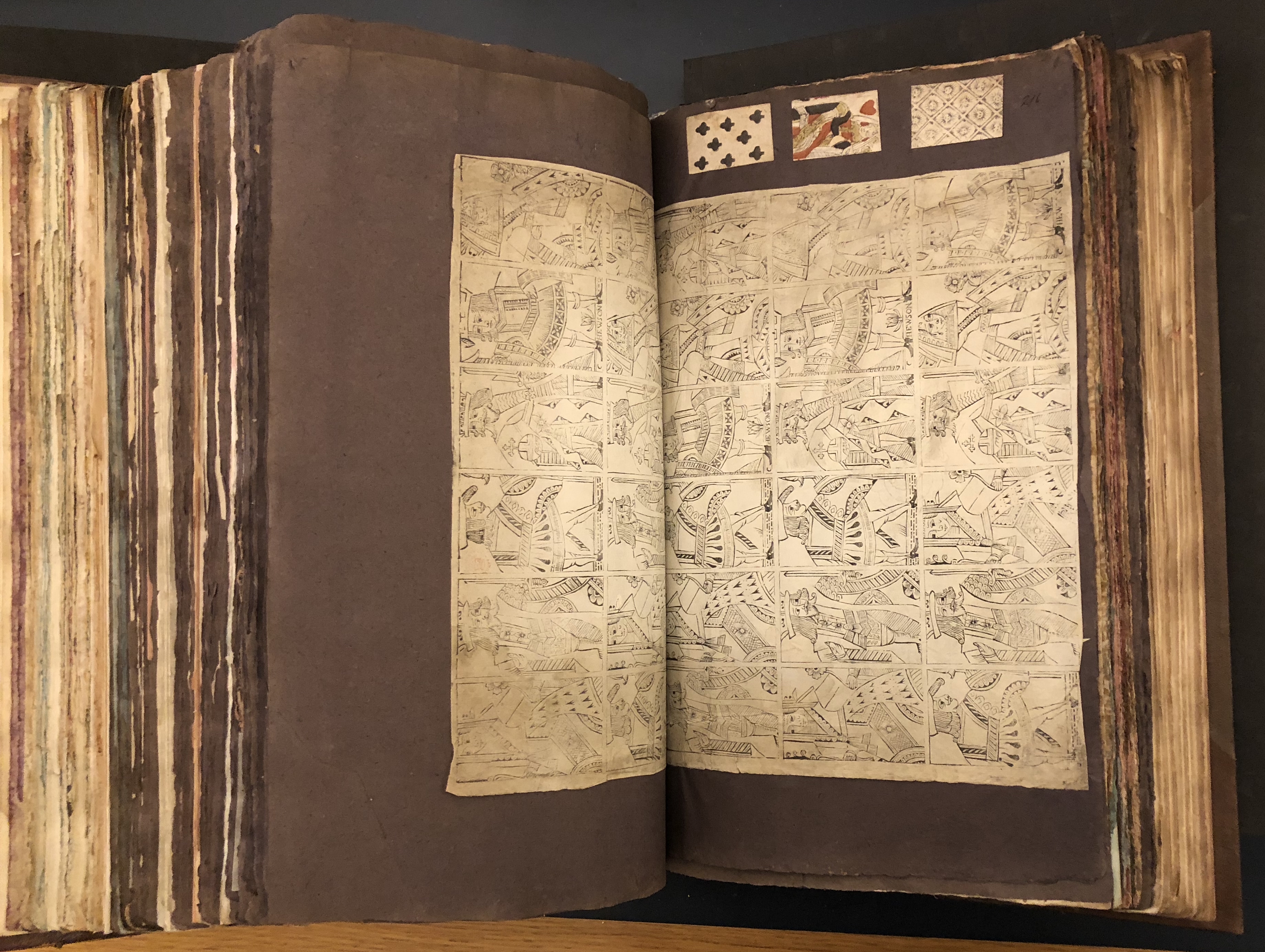 Photograph of a set of uncut playing cards pasted into a large volume of paper specimens
