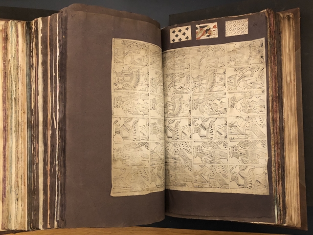 Photograph of a set of uncut playing cards pasted into a large volume of paper specimens