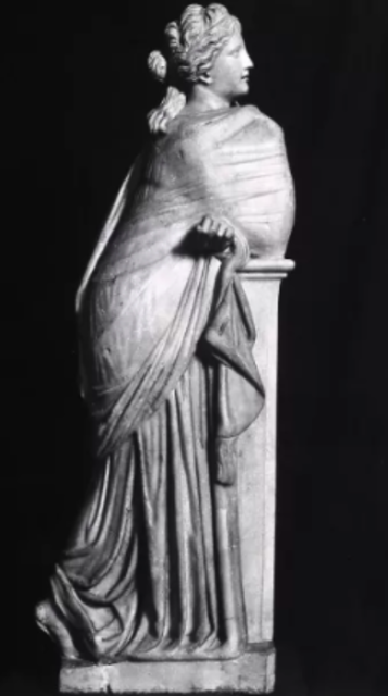 A Roman marble statue of Polyhymnia, the Muse of sacred poetry, standing with her cloak draped over her left shoulder in a contemplative pose. The statue represents Polyhymnia through her serene and thoughtful demeanor. The Muse Polyhymnia statue in the Museo Nacional del Prado in Madrid, Spain is 68 centimeters tall, 51 centimeters wide, and 33 centimeters at the base.
