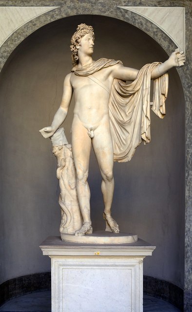 This is a white marble statue of Apollo Belvedere. The figure of Apollo stands frontally, with his weight shifted onto one leg. His right arm is extended, as he has just released an arrow, while his left arm is covered with his robe. Apollo has a quiver slung across his right shoulder. He is entirely nude except for a pair of sandals on his feet and a robe draped over his shoulder and thrown back.
