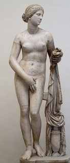 Nude statue  of the Goddess Aphrodite showing her reaching for her towel while covering her pubic area leaving her breasts exposed.