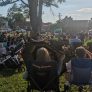 People sitting in lawn chairs and on blankets on the grass