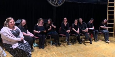 Eight people sitting on a stage