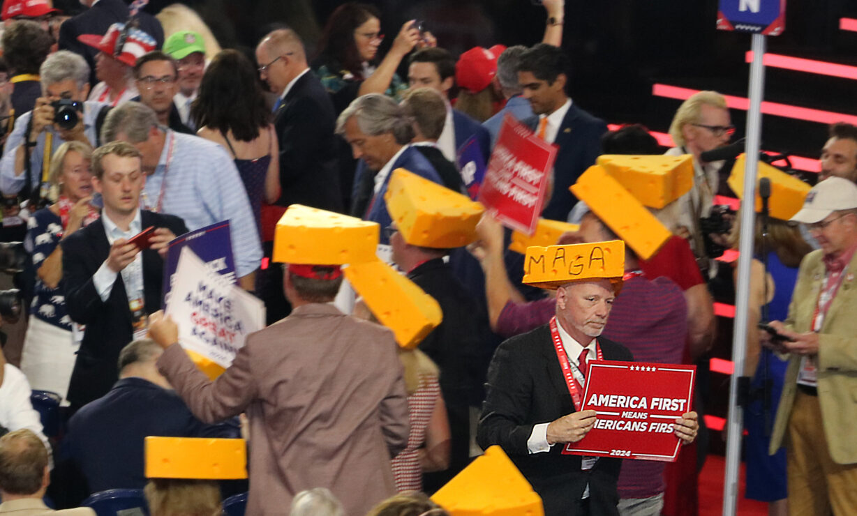 Mean in suits with yellow foam cheese hats