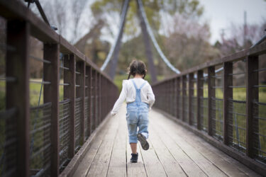 Little girl crossing a bridge.