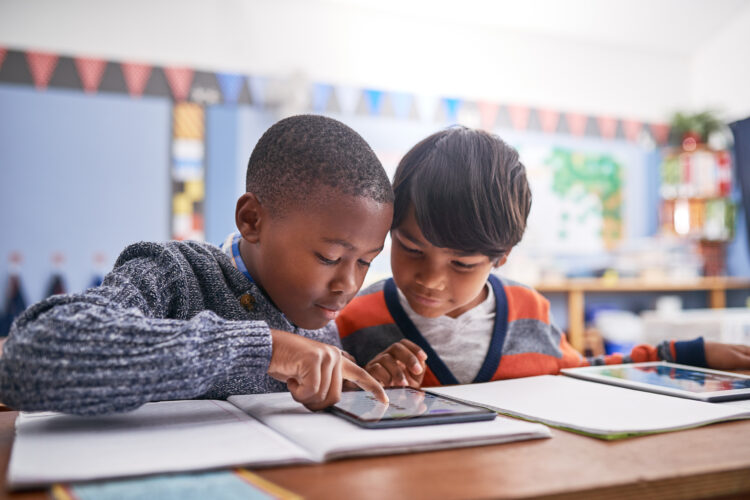 Cropped shot of elementary school children using a tablet in class