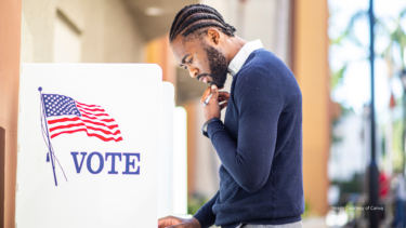 Image of a black man voting. Credit: Canva