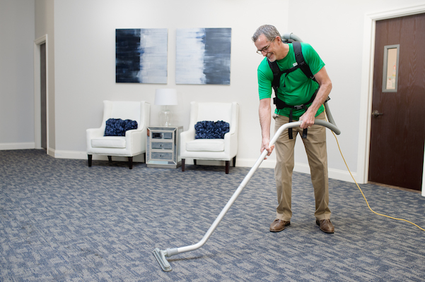 janitor vacuuming waiting area for office clients