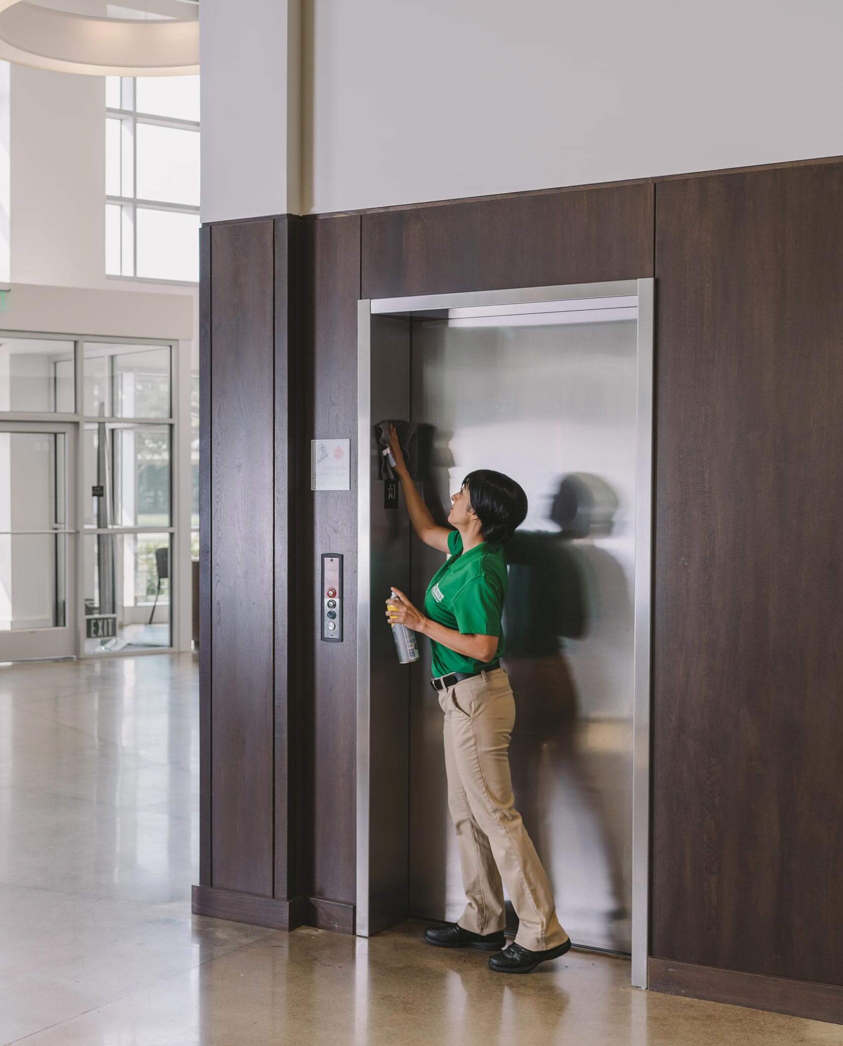 Commercial cleaning worker cleaning lobby area of corporate buiilding