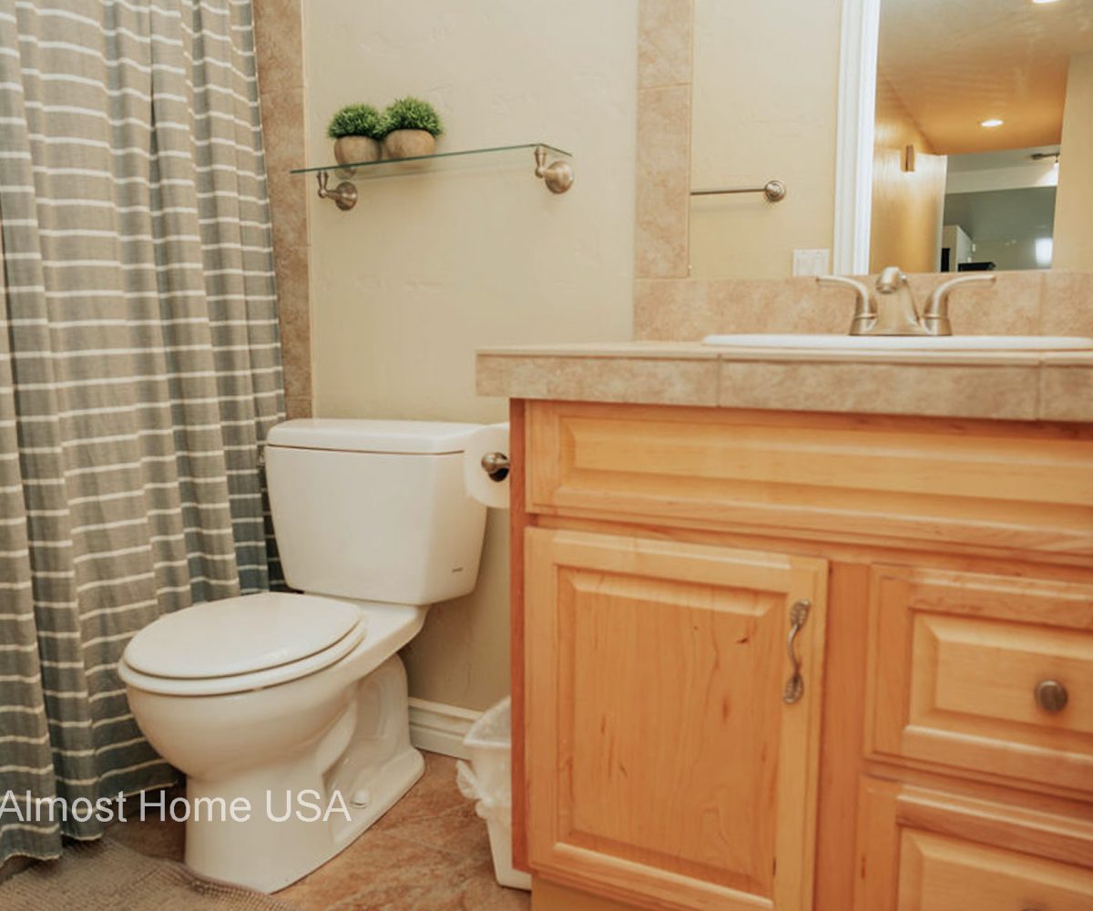 Bathroom toilet and vanity in furnished home located in Sandy, Utah.
