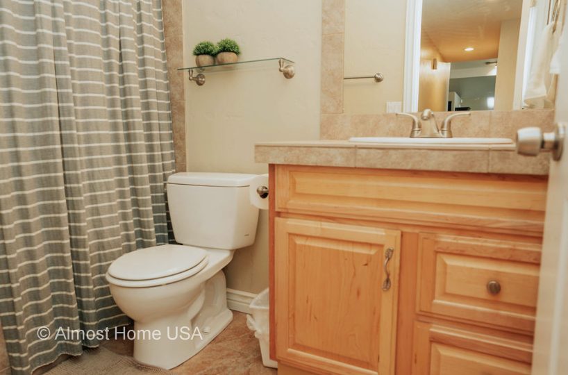 Bathroom toilet and vanity in furnished home located in Sandy, Utah.