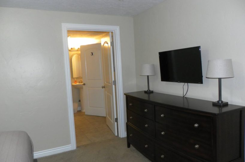 Smart TV in master bedroom in furnished home located in Sandy Utah.