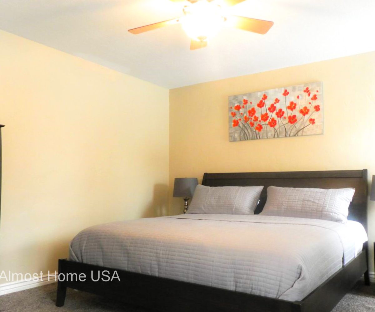 King bed and wall art in master bedroom located in furnished home in Sandy Utah.