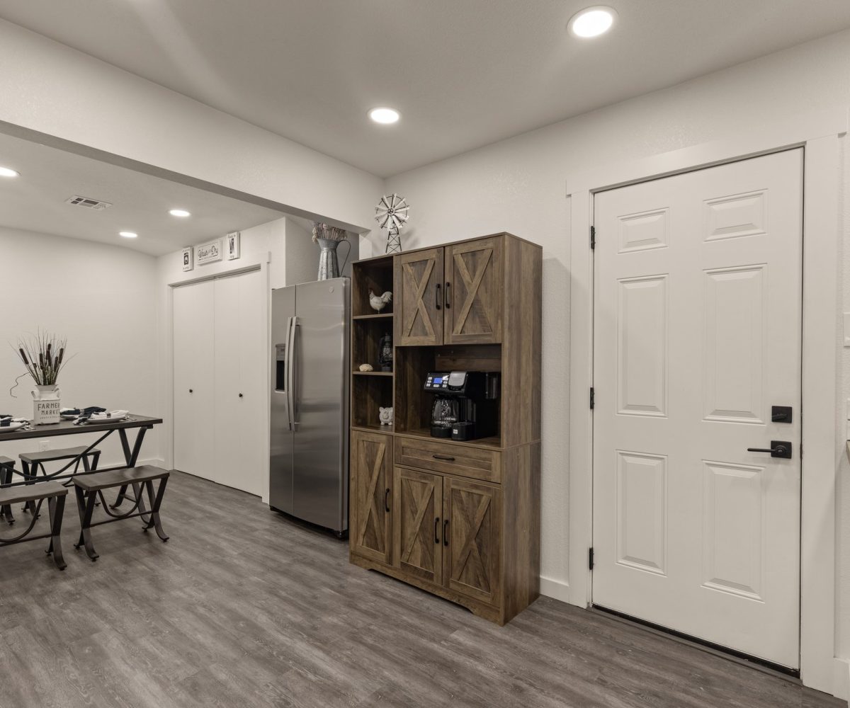 Fridge and dining area in furnished home in Tulsa, OK.