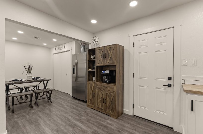 Fridge and dining area in furnished home in Tulsa, OK.