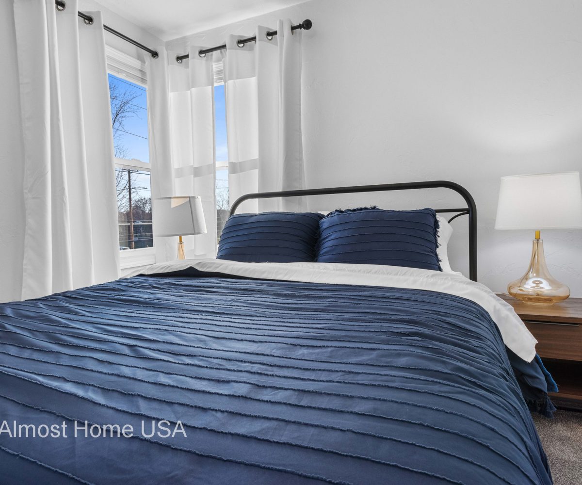 Closeup photo of queen bed in main bedroom in furnished rental in Sturgeon Bay, WI.