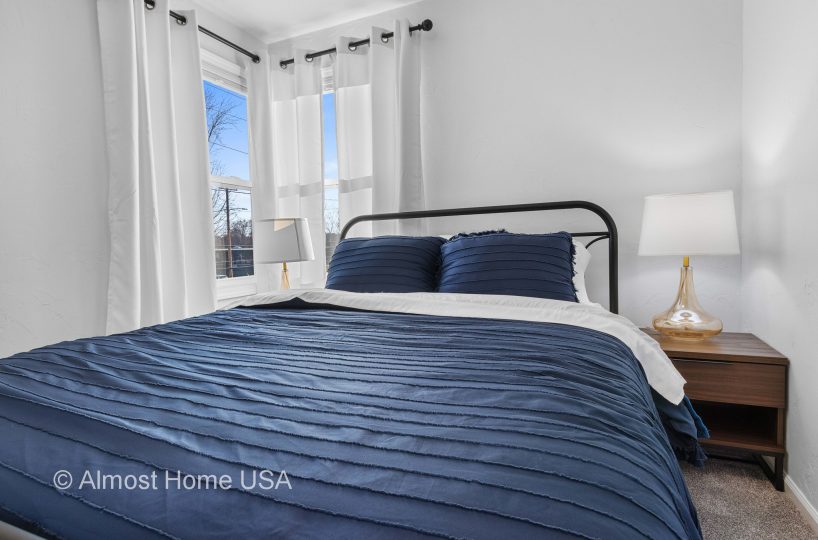 Closeup photo of queen bed in main bedroom in furnished rental in Sturgeon Bay, WI.