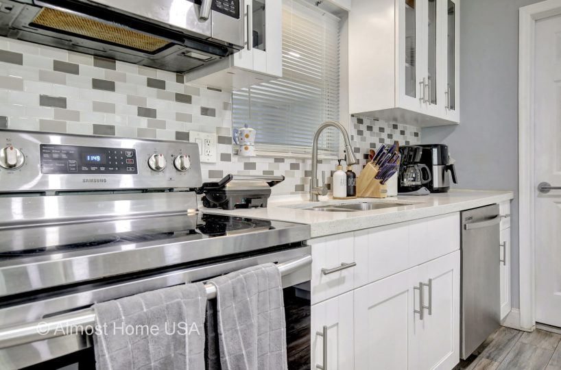 Updated kitchen with stainless steel appliances and backsplash in furnished home located in Miami, FL.