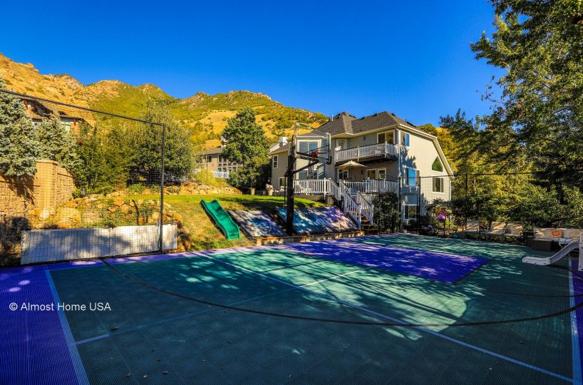 Basketball court and backyard at furnished home in Holladay, UT.