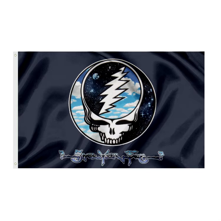 “Steal Your Face,” often mistakenly called “Space Your Face,” is one of the most iconic symbols associated with the Grateful Dead. Officially known as the “Steal Your Face” skull or “Lightning Skull,” the design features a white skull split by a bold red and blue lightning bolt. It first appeared on the cover of the 1976 live album Steal Your Face and quickly became a visual shorthand for the band’s identity and culture. The symbol was created by artist Owsley “Bear” Stanley along with Bob Thomas. Originally, it wasn’t meant to be a logo at all—it was designed for practical purposes. The band needed a quick way to identify their equipment during tours, especially their sound gear, which was extensive and often mixed in with other bands’ setups. The striking skull-and-lightning design made it easy to spot from a distance, and its bold simplicity helped it stand out. Over time, the image took on a life of its own. Fans embraced it as a badge of belonging, and it became deeply tied to the Deadhead community. The lightning bolt is often interpreted as representing energy, duality, or the electrifying experience of live performances, while the skull can symbolize mortality, transcendence, or the psychedelic exploration central to the band’s ethos. Though many call it “Space Your Face,” likely blending the band’s improvisational “Space” segments with the imagery, the official name remains “Steal Your Face.” Regardless of the name, the symbol endures as a powerful cultural icon. It represents not just a band, but a movement rooted in music, freedom, experimentation, and a shared sense of journey that continues to resonate with fans across generations. Grateful Dead Flags