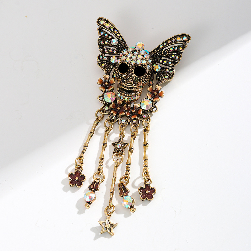 Gold-plated-skull-butterfly-pin-with-rhinestone-wings-and-decorative-dangling-charms