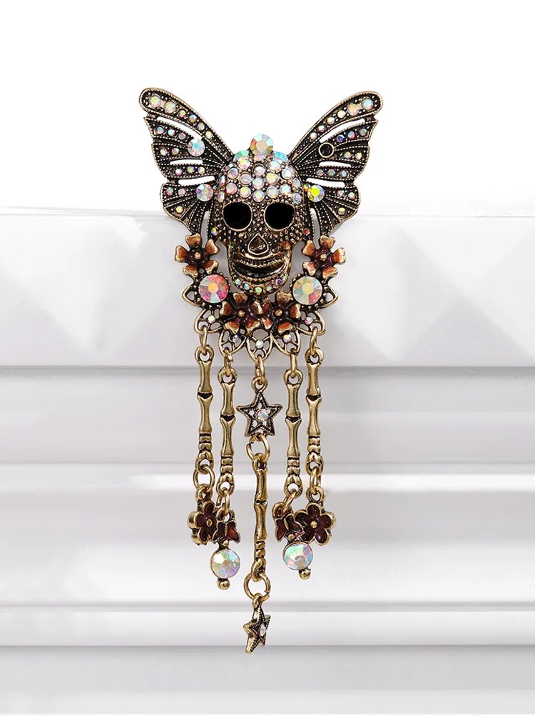 Gold plated skull butterfly pin with rhinestone wings and decorative dangling charms