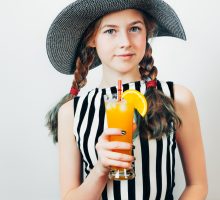 young woman holding a glass of sweet fruit juice