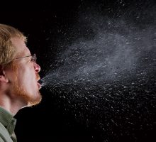 Man sneezing viral particles