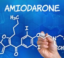 Hand with pen drawing the chemical formula of Amiodarone
