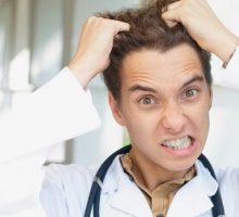an angry male doctor pulling out his hair in frustration