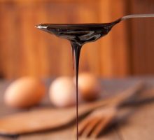 Blackstrap molasses for baking drizzling from a teaspoon