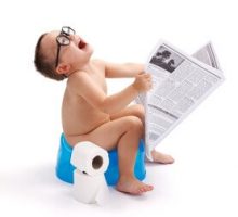 little boy sitting on blue potty holding newspaper