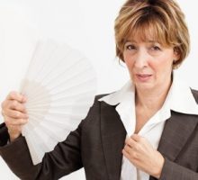 Businesswoman in Menopause fanning herself