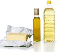 Butter in paper and two bottles of different types of oil,