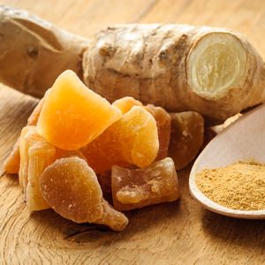 Three kinds of ginger - ground spice fresh and candied on rustic table.